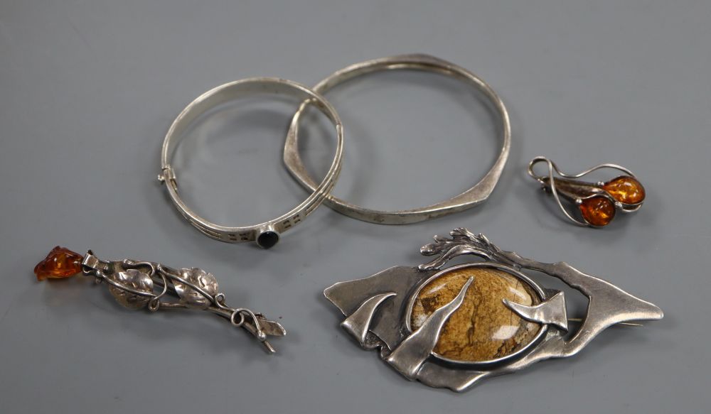 Two amber set brooches, one silver, two silver bangles and a 925 and hardstone set modernist brooch, 95mm.